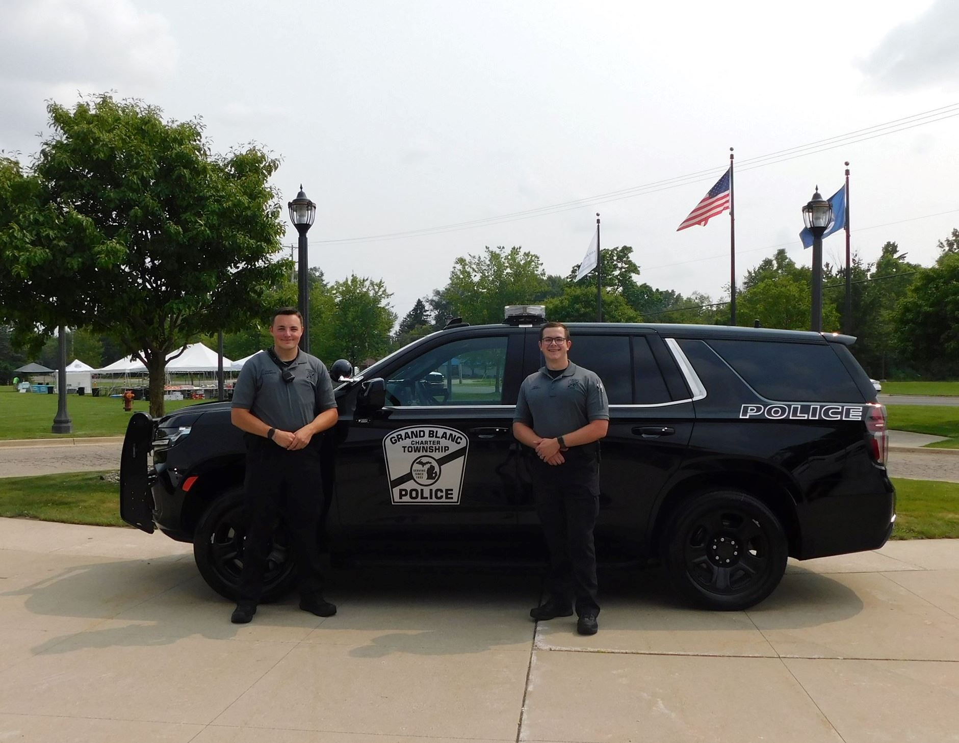 Two cadets standing in front of a Grand Blanc Township Police vehicle